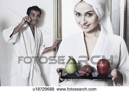 Stock Photo - Portrait of a young woman holding a tray of fruit. Fotosearch