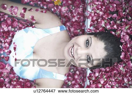 Portrait of a young woman in a swimming pool filled with rose petals View Large Photo Image Stock Photo - Portrait of a young woman in a swimming pool filled with rose petals. Fotosearch