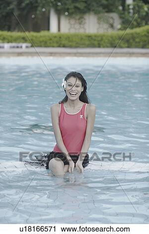 Portrait of a young woman sitting in a swimming pool View Large Photo Image Stock Image - Portrait of a young woman sitting in a swimming pool. Fotosearch