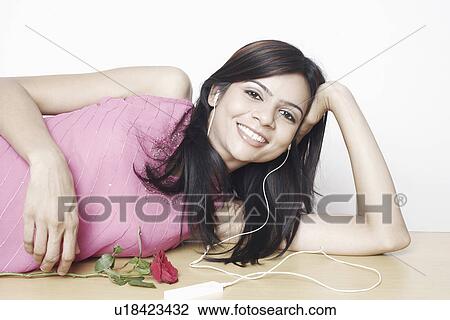 Portrait of a young woman wearing headphones listening to music View Large Photo Image Stock Image - Portrait of a young woman wearing headphones listening to music. Fotosearch