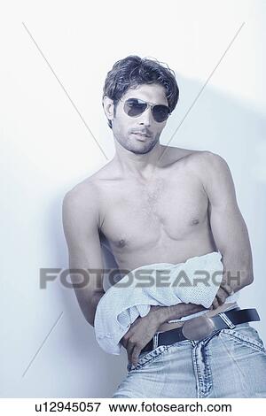 Young man standing bare chested View Large Photo Image Stock Photo - Young man standing bare chested. Fotosearch