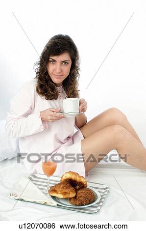 Stock Photograph - Woman, Breakfast, Having breakfast, Beauty, Young, Young woman, Brown hair. Fotosearch