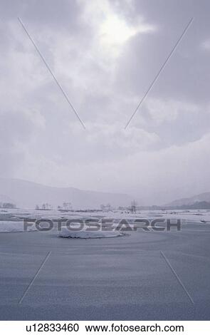 Stock Image - Cloudy Sky Above Frozen Lake. Fotosearch
