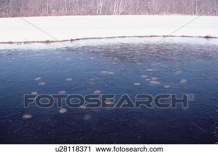 Stock Image - Frozen Pond Near Snowy Field. Fotosearch