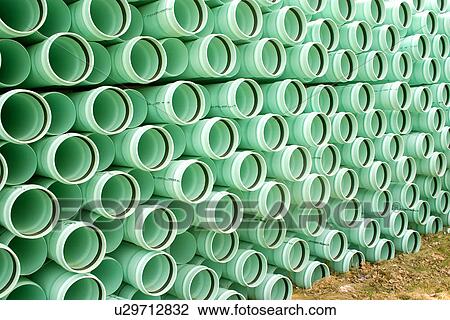 Stock Image - Beautiful green plastic pipes stacked in a lumberyard. Fotosearch