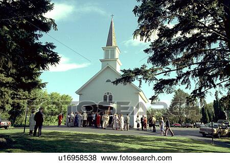 Stock Photo - Priest greeting wedding guests entering Catholic Church. Fotosearch