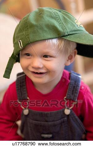 Toddler laughing and wearing baseball hat View Large Photo Image Stock Image - Toddler laughing and wearing baseball hat. Fotosearch