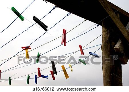 Stock Image - Clothesline with dangling multicolored clothes pins. Fotosearch
