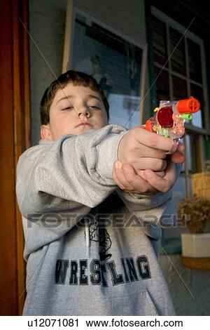 Boy age 8 aiming colorful toy cap gun View Large Photo Image Stock Image - Boy age 8 aiming colorful toy cap gun. Fotosearch
