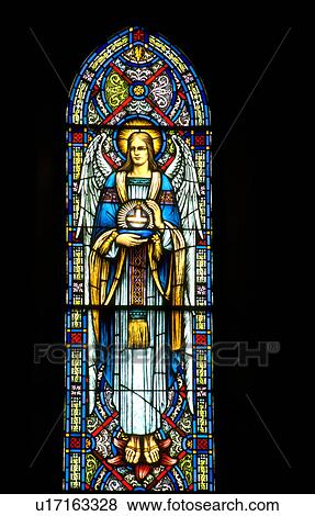 Stock Photo - Angel holding religious symbol stained glass window. Fotosearch