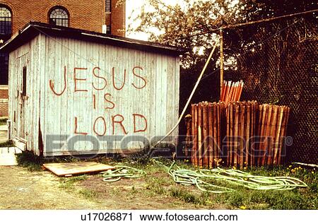 Stock Image - Utility shack with Jesus is Lord spray painted on it. Fotosearch