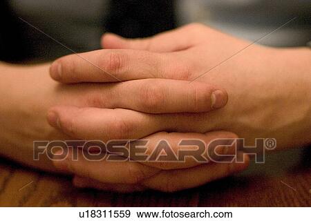 Stock Photo - Folded hands of a thoughtful person. Fotosearch