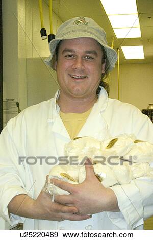 Stock Photo - Happy cheese packager and and deli customer service manager holding bags of Cheese. Fotosearch