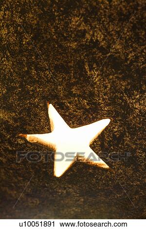 Stock Image - Close-up of decorative glowing star shape in metal lamp. Fotosearch