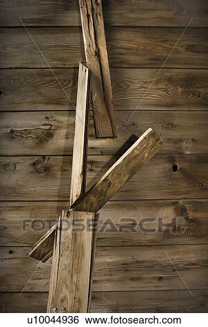 Stock Photograph - Close up of side of rustic wooden building with wood pieces hanging down.. Fotosearch