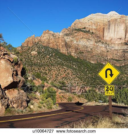 Curve caution sign on two lane road winding through rocky desert cliffs in Zion National Park, Utah. View Large Photo Image Stock Photo - Curve caution sign on two lane road winding through rocky desert cliffs in Zion National Park, Utah.. Fotosearch