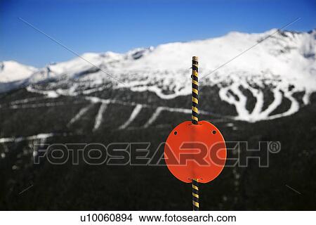 Red sign with ski slopes in background. View Large Photo Image Picture - Red sign with ski slopes in background.. Fotosearch