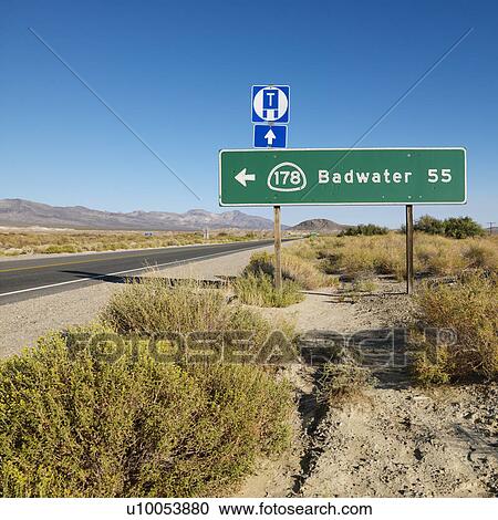 Stock Image - Road sign on side of desert road with direction to Badwater, Death Valley.. Fotosearch