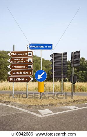 Stock Photograph - Road signs pointing different directions, Tuscany.. Fotosearch