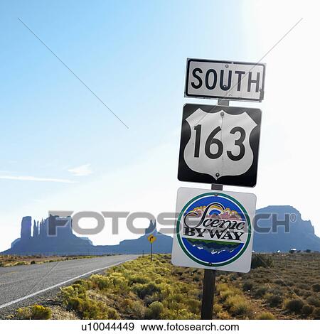 Stock Photo - Sign for Scenic Byway 163 south beside road with rock formations in background in Monument Valley, Utah.. Fotosearch