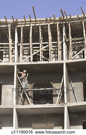 Stock Photograph - Building Exterior, Building Structure, Casual Clothing, Clear Sky, Construction Site. Fotosearch
