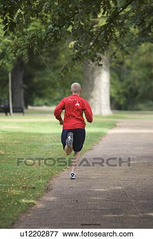 Stock Photo - Focus On Foreground, Jogging, Lush Foliage. Fotosearch