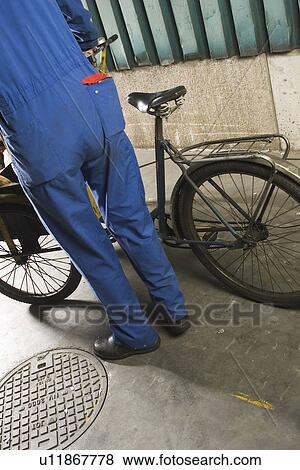 Stock Photo - Bicycle, Day, Holding, Manual Worker, Mechanic. Fotosearch