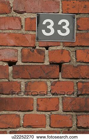 Stock Image - wall, brickwork, brick, house number, sign, signboard. Fotosearch