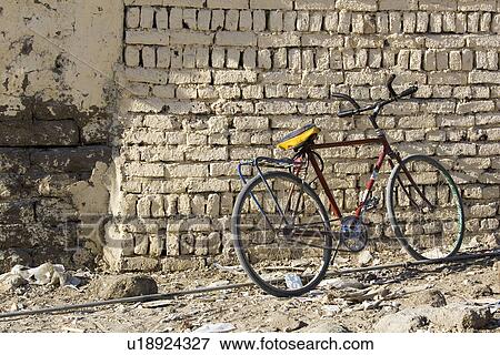 Stock Photo - Bicycle, Brick Wall, Building, Day, Dirt Road. Fotosearch