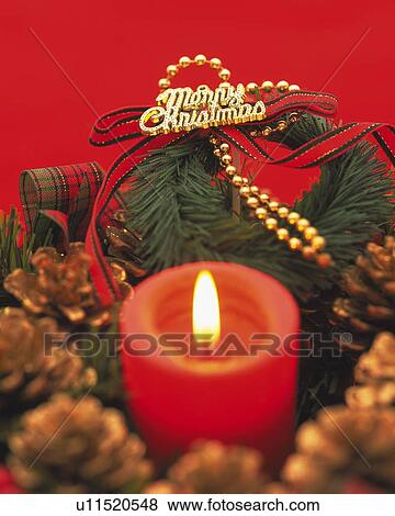 Stock Photo - Burning Candle in the Center of Christmas Wreath, Close Up, Differential Focus, In Focus, Out Focus. Fotosearch