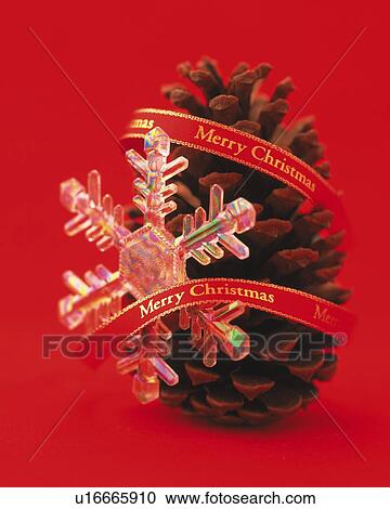 Stock Image - Crystal of Snow and Pine Cone Wrapped by Red Ribbon, Side View, Close Up. Fotosearch