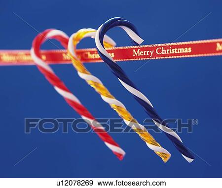 Stock Photo - Three Candy Sticks Handing on Ribbon, Close Up, Side View, Differential Focus, In Focus, Out Focus. Fotosearch