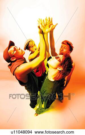 Four Young Adult Men Raising Hands Up, Photography, High Angle View, Toned Image View Large Photo Image Picture - Four Young Adult Men Raising Hands Up, Photography, High Angle View, Toned Image. Fotosearch