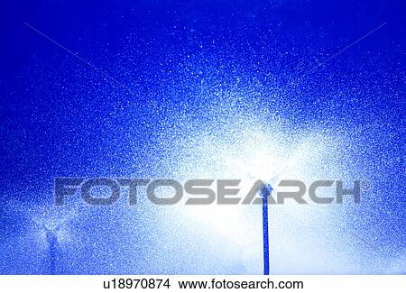 Low angle view of water flowing from sprinklers View Large Photo Image Picture - Low angle view of water flowing from sprinklers. Fotosearch