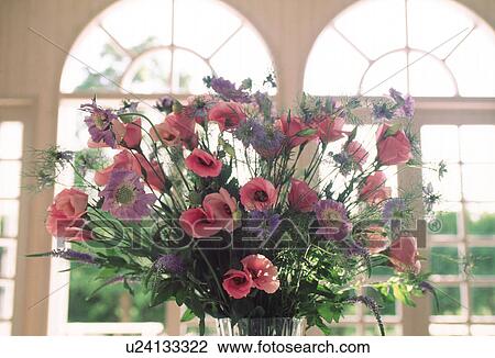 A vase of flowers displayed near a window View Large Photo Image Stock Image - A vase of flowers displayed near a window. Fotosearch