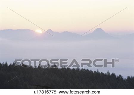 Stock Photography - The Morning Sun And A Mountain Range. Fotosearch