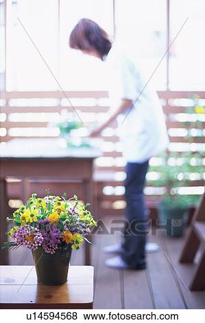 Flower bouquet in bucket with a woman standing in the background View Large Photo Image Stock Photo - Flower bouquet in bucket with a woman standing in the background. Fotosearch