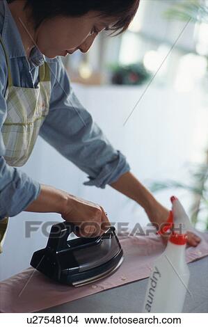 Mid adult woman ironing View Large Photo Image Picture - Mid adult woman ironing. Fotosearch