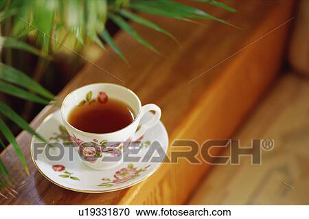 Stock Image - Tea cup on sofa. Fotosearch