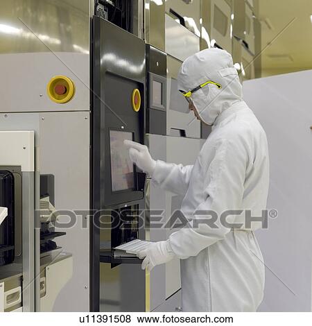 Stock Photo - A technician in white lab suit working in laboratory. Fotosearch