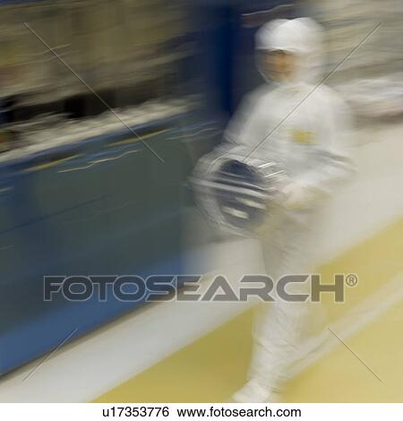 Stock Photograph - Blurred view of a lab worker walking in his white suit in the laboratory. Fotosearch
