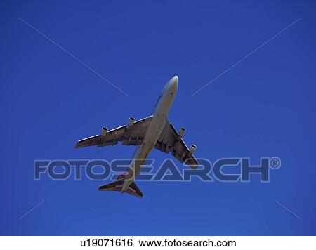 Stock Photograph - Low angle view of a plane taking off. Fotosearch