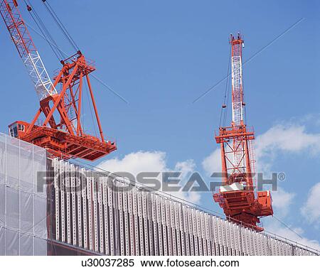Low angle view of huge cranes at construction site View Large Photo Image Stock Photography - Low angle view of huge cranes at construction site. Fotosearch