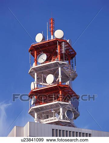Stock Photo - Low angle view of satellite dishes mounted on a tower. Fotosearch