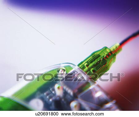 Stock Image - Close up of a plug inserted in the socket of an electrical device. Fotosearch