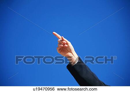 Stock Photograph - A man pointing his index finger towards the sky. Fotosearch