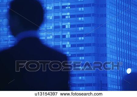 Stock Photo - Blurred view of a mature man at the foreground with building at the background. Fotosearch