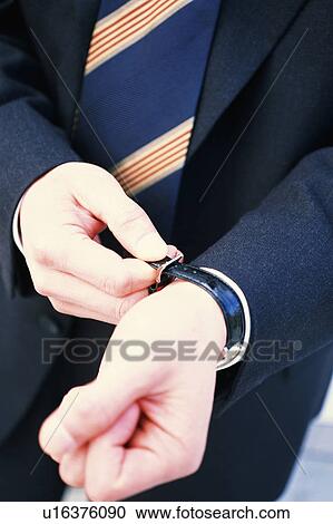 Stock Image - Close up of a business man wearing a wrist watch. Fotosearch