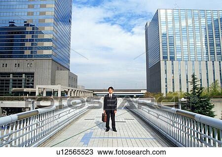 Front view of a man in suit with commercial buildings at the back. View Large Photo Image Stock Image - Front view of a man in suit with commercial buildings at the back.. Fotosearch