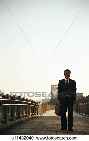 Front view of a mature man in suit with commercial buildings at the back View Large Photo Image Stock Image - Front view of a mature man in suit with commercial buildings at the back. Fotosearch